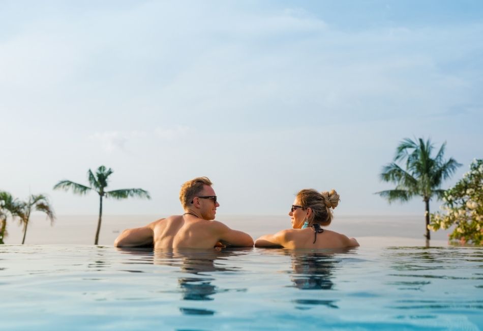 Happy Couple in Infinity Pool in Four Seasons Resort Bali At Jimbaran Bay